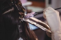 Перукар фарбування волосся свого клієнта в салоні — стокове фото