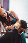 Uomo ottenere la barba rasata con pennello da barba in negozio di barbiere — Foto stock
