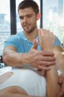 Male physiotherapist giving arm massage to female patient in clinic — Stock Photo