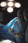 Чоловічі хірурги обговорюють під час роботи в операційній кімнаті в лікарні — стокове фото