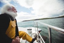 Pescatore guardando il mare dalla barca da pesca — Foto stock
