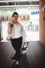 Ganzkörperporträt einer Frau mit Gepäck am Bahnhof — Stockfoto