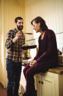 Man feeding food to woman in kitchen at home — Stock Photo