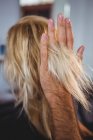 Обрезанное изображение волос стилист укладки женщины волосы в салоне — стоковое фото