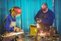 Schweißer sägen Metall mit elektrischen Werkzeugen und Schweißen in der Werkstatt — Stockfoto