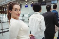 Mulher esperando na fila em um balcão de check-in com bagagem dentro do terminal do aeroporto — Fotografia de Stock