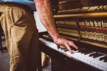 Специалист по ремонту ретро-фортепиано в мастерской — стоковое фото