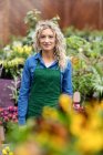 Retrato de florista feminina sorrindo no centro de jardim — Fotografia de Stock