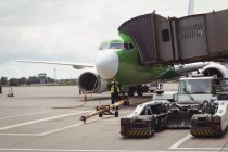 Літак із завантажувальним мостом готується до вильоту в терміналі аеропорту — стокове фото