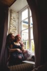 Junges Hipster-Paar sitzt zu Hause am Fenster — Stockfoto