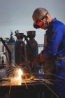 Schweißer arbeitet in Werkstatt an Metallstück — Stockfoto