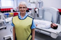 Портрет усміхненого лікаря, що стоїть у рентгенівській кімнаті в лікарні — стокове фото