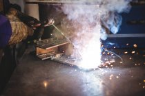 Cropped image of welder welding metal in workshop — Stock Photo