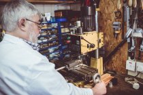 Mid section of horologist using a horological milling machine in the workshop — Stock Photo