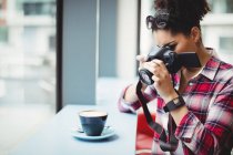 Femme photographiant café tout en se tenant au restaurant — Photo de stock