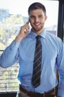 Портрет бизнесмена разговаривающего по мобильному телефону в офисе — стоковое фото