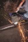 Soudeur découpe métal avec outil électrique en atelier — Photo de stock