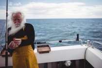 Pescador preparando caña de pescar en barco de pesca - foto de stock