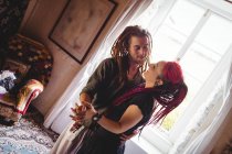 Junges Paar tanzt zu Hause am Fenster — Stockfoto