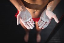 Imagen recortada de pole dancer con polvo en las manos en el gimnasio - foto de stock