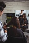 Smiling female hairdresser working on client in hair salon — Stock Photo