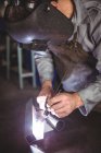 Зварювальник працює над металом у майстерні — стокове фото