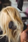 Cropped image of Woman getting her hair dried with hair dryer in hair salon — Stock Photo