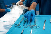 Chirurgien prenant un ciseau du plateau pendant l'opération — Photo de stock