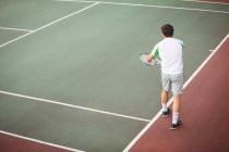 Человек с теннисной ракеткой готов служить в суде — стоковое фото
