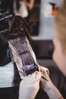 Abgeschnittenes Bild der Friseurin, die im Salon Haare ihrer Kundin färbt — Stockfoto