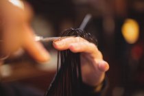 Abgeschnittenes Bild eines Mannes, der sich im Friseurladen die Haare mit der Schere schneiden lässt — Stockfoto