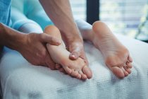 Geschnittenes Bild eines männlichen Physiotherapeuten, der weiblichen Patientin eine Fußmassage gibt — Stockfoto