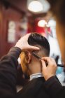 Mann lässt sich im Friseurladen Haare mit Rasiermesser schneiden — Stockfoto