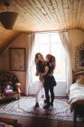 Full length of young couple dancing against window at home — Stock Photo