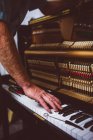 Tecnico di pianoforte che ripara pianoforte vintage in officina — Foto stock