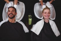 Парикмахеры сушат клиентам волосы полотенцами в салоне — стоковое фото