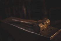 Крупный план кузнечного молота, лежащего на наковальне — стоковое фото