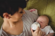 Close up of mother feeding her baby in living room at home — Stock Photo