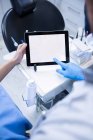 Cropped image of Dentist and dental assistant working on digital tablet at dental clinic — Stock Photo