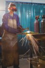Saldatore donna che lavora su un pezzo di metallo in officina — Foto stock