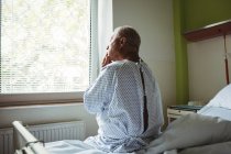 Продуманий старший чоловік сидить на ліжку в лікарні — стокове фото