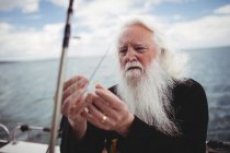 Selektiver Fokus der Fischer bei der Anpassung des Angelhakens am Fischerboot — Stockfoto