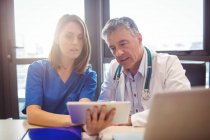 Médico discutiendo con enfermera sobre tableta digital en el hospital - foto de stock