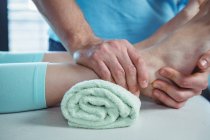 Imagem recortada de fisioterapeuta masculino dando massagem nos pés para paciente do sexo feminino na clínica — Fotografia de Stock