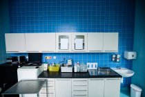 Cabinets, refrigerator, wash basin, worktop and sink in hospital room — Stock Photo