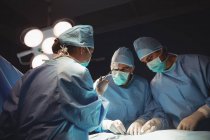 Team of surgeons performing operation in operation room at hospital — Stock Photo
