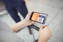 Woman using mobile phone in airport terminal — Stock Photo
