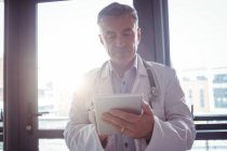 Médico con estetoscopio usando tableta digital en el hospital - foto de stock