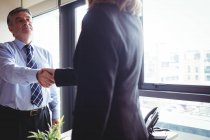 Обрізаний образ бізнес-леді і бізнес-леді тремтять руками в офісі — стокове фото
