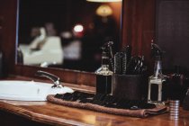 Barber spray bottles, brush and accessories on dressing table in barber shop — Stock Photo
